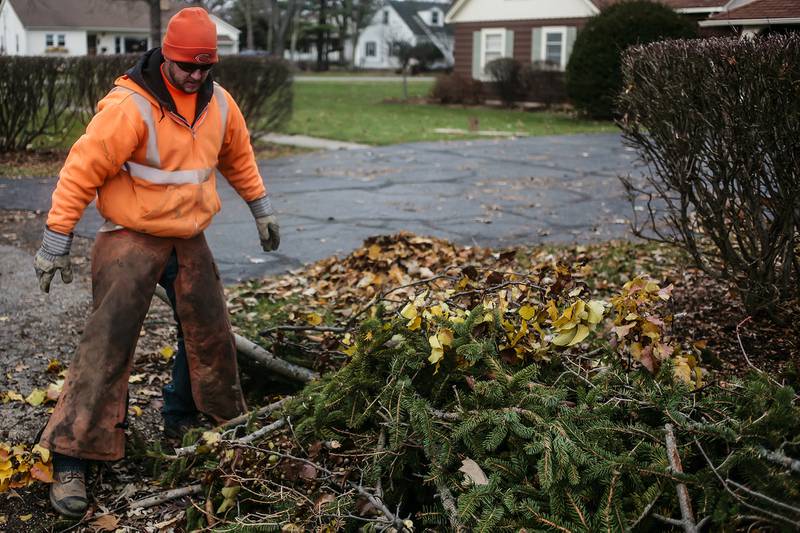 Paul Clements of the McHenry Public Works Department cleans up debris from from storm damage Monday, Nov. 18, 2013, in McHenry.