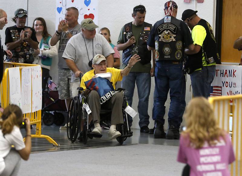 World War II U.S. Marine Corps veteran John Rickerd is wheeled into McHenry Community High School by his son, Mark, as veterans returned from an Honor Flight trip to Washington D.C. on Sunday, Aug. 27, 2023.