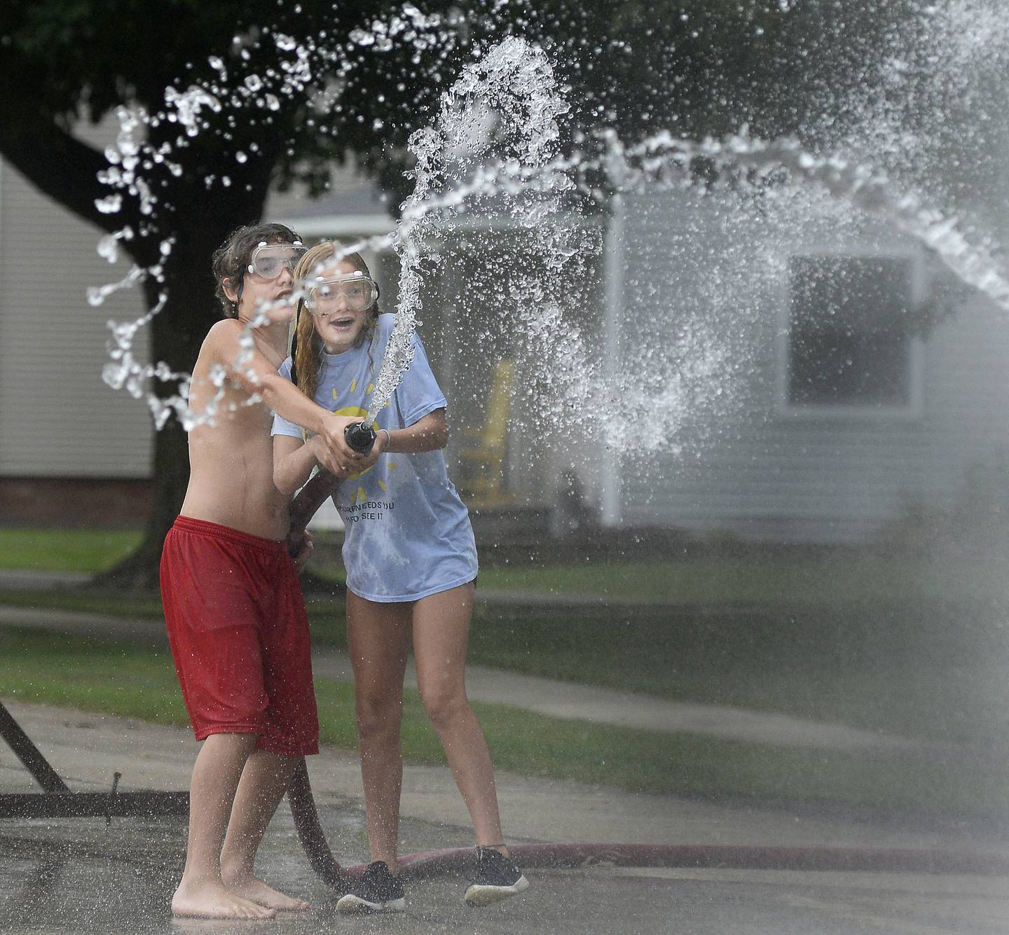 Ollie Kearfott and his sister Leah battle to win their first round of the water fights competition Saturday, Aug. 20, 2022, during the Grand Ridge Community Fest.