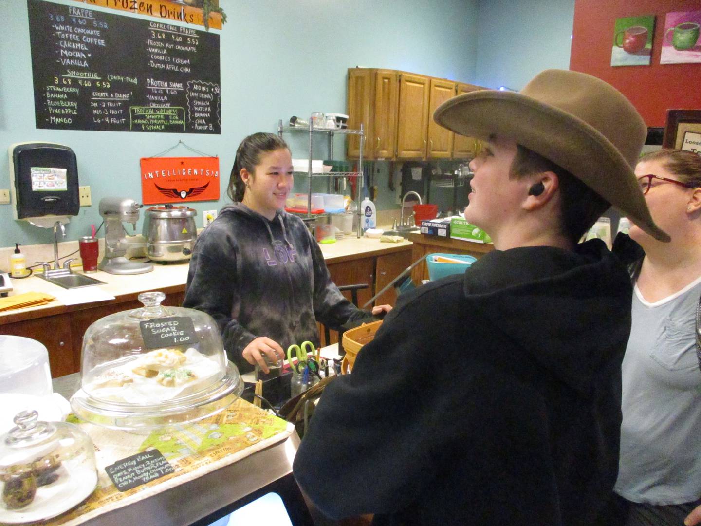 Employee Hannah Yang takes customer orders at the Book and Bean Cafe. She is the second in her family after her older brother to have worked at the coffee shop at the Joliet Public Library Black Road Branch. Dec. 2, 2023.