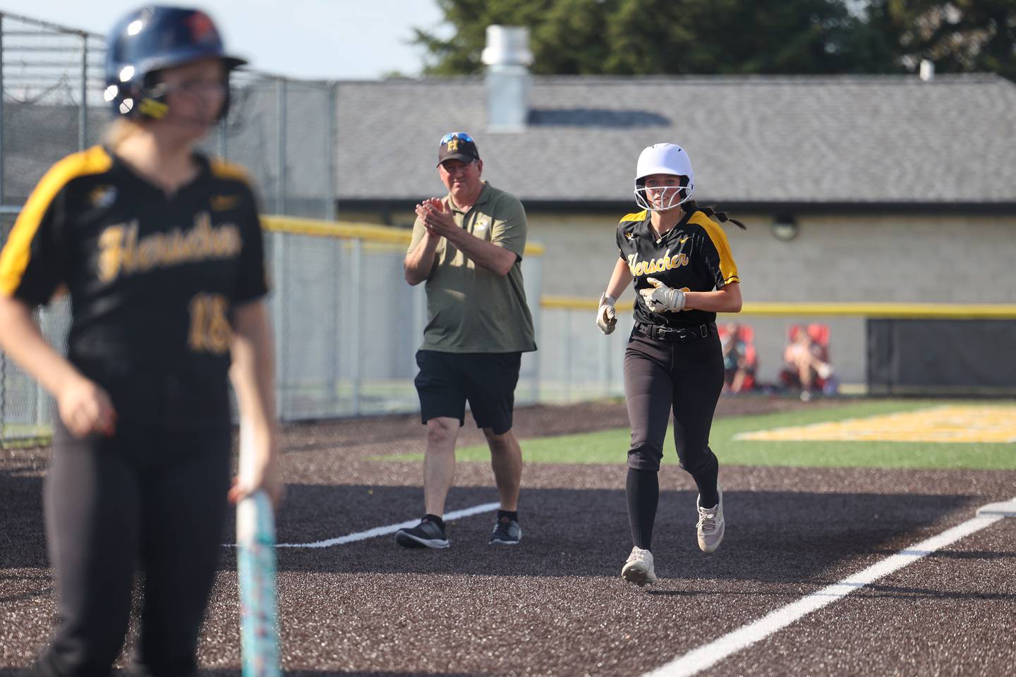 Herscher's Emery Fritz jogs to home plate on a Keira Ahramovich home run as head coach Mike Cann applauds during the Tigers' 13-6 victory against Central on Wednesday, May 14, 2025.
