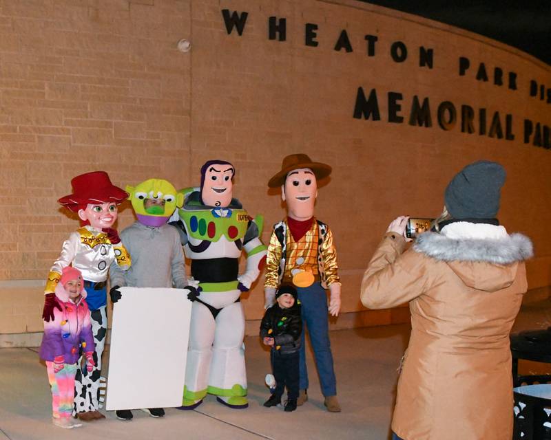 Ashley of Schaumburg takes a picture of her kids Kendall, 6 years old, and Dylan, 3 years old, with characters from Toys Story before the start of the Wheaton Holiday Parade held on Friday Nov. 24, 2023.