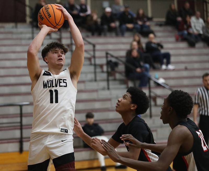 Prairie Ridge's Elijah Loeding shoots the ball over Huntley's Isaac Muze (center) and Isaiah Onu (right) during a Fox Valley Conference boys basketball game on Wednesday, Jan. 21, 2026, at Prairie Ridge High School in Crystal Lake.