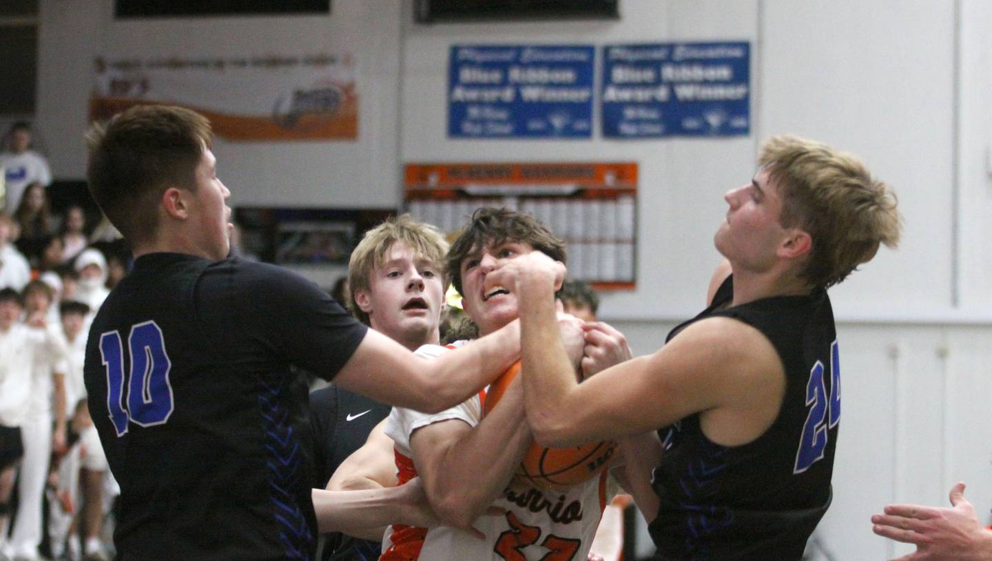 McHenry’s Blake Renfro, center, fights through Burlington Central’s Colton O’Neil, left, and Bennek Braden, right, under the hoop in varsity boys basketball on Friday, Dec. 5, 2025, at McHenry Community High School in McHenry.