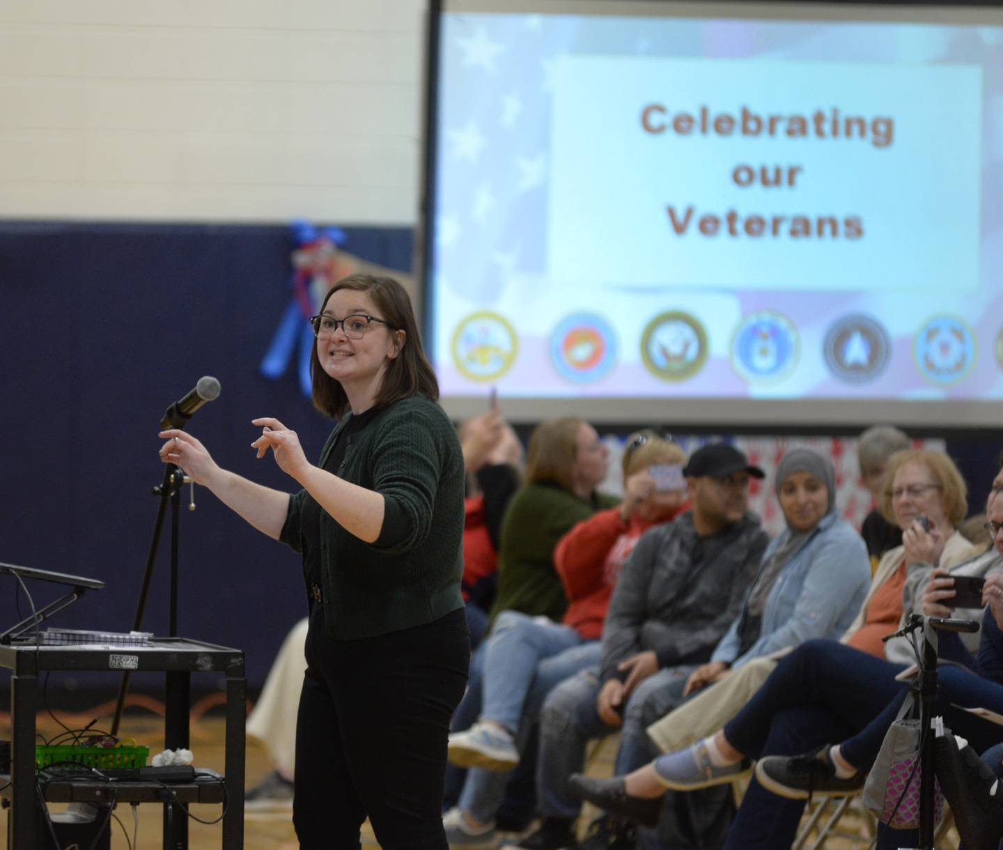 Centennial Grade School music teacher Jordann Fishman directed students as they sang patriotic songs at the Veterans Day ceremony in Polo on Monday, Nov. 11, 2024.
