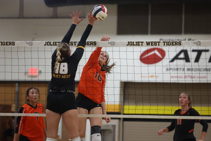 Lincoln-Way West’s Ashley Dace hits a shot over the arms of Joliet West’s Peyton Darguzis on Tuesday, Sept. 12, in Joliet.