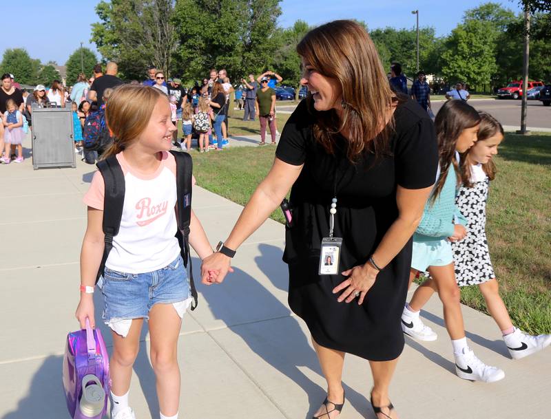 Principal Samantha Aversa walks with second grade student Grace Laskowski at Kaneland John Stewart Elementary in Elburn on Wednesday, Aug. 14, 2024.