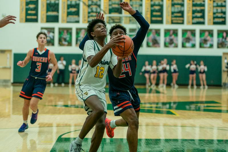 Waubonsie Valley's Tyreek Coleman (12) drives to the hoop against Oswego’s Jeremiah Akin (24) during a Waubonsie Valley 4A regional semifinal basketball game at Waubonsie Valley High School in St.Charles on Wednesday, Feb 22, 2023.