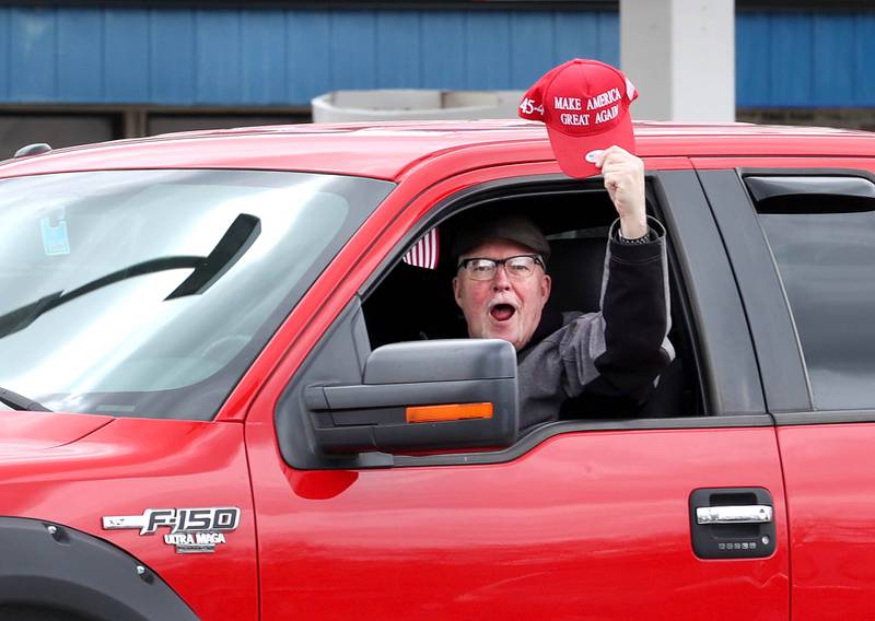 A supporter of President Donald Trump lets his feelings be known as he drives down Lincoln Highway Saturday, April 5, 2025, past hundreds of people at a Hands Off! protest in DeKalb. The group of protesters gathered to rally against various policies of the Trump administration.