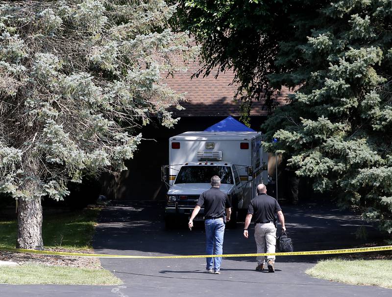 McHenry County Sheriff's office investigators walk toward the home in 5800 block of Wild Plum Road in unincorporated Crystal Lake on Thursday, Aug. 10, 2023, as they continued to investigate the scene where four family members, including three females and a male “aggressor,” were killed Wednesday.