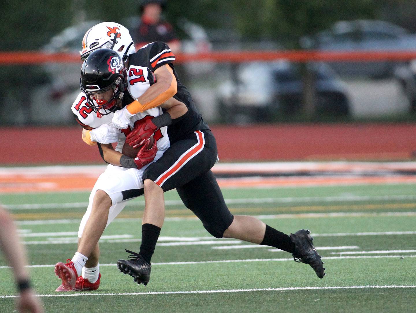 Lincoln-Way Central’s Ryan Schissler (12) is taken down by a St. Charles East defender during the season opener at St. Charles East on Friday, Aug. 26, 2022.