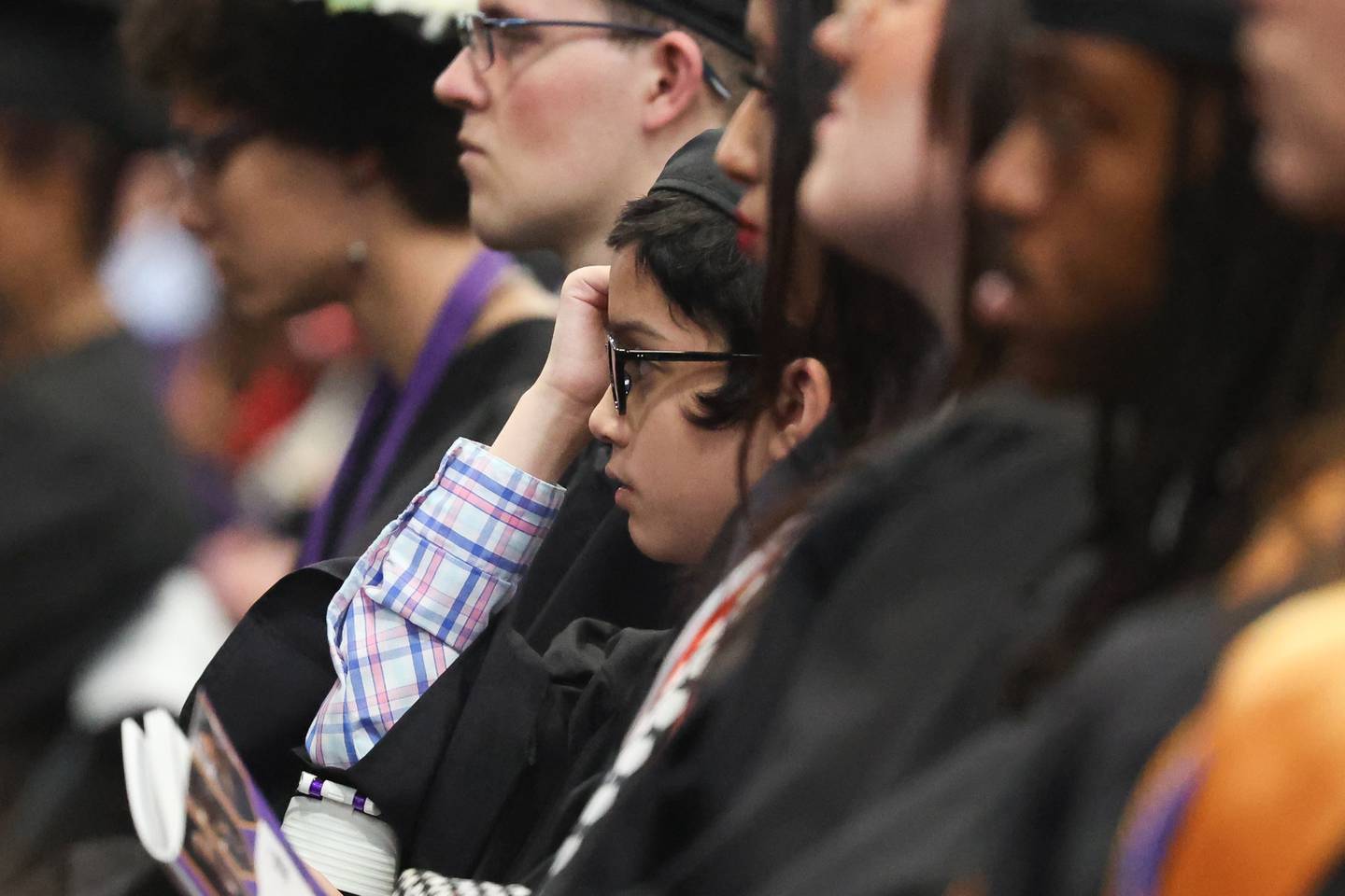 Benjamin Bamburc sits with other graduates at the Joliet Junior College Commencement Ceremony on Friday, May 19, 2023, in Joliet.