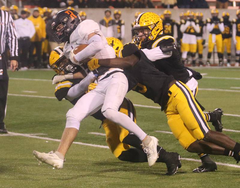 Rochester's Jack Buecker is chased down by St. Laurence's Sebastian Morales, Jaylen Hayes and Timmy Allison during the Class 4A State football championship on Friday, Nov, 24, 2023 at Hancock Stadium in Normal.