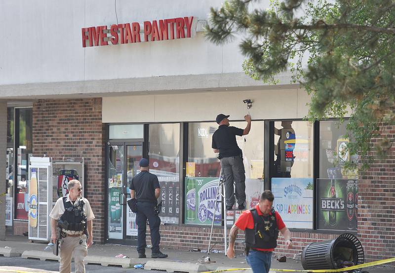 Police investigators mark an apparent bullet hole on the front of Five Star Pantry at 10S620 Kingery Hwy. in Willowbrook on Monday, June 20. 2023. There was  a mass shooting there early Sunday morning as a unsanctioned party took place in the parking lot.
