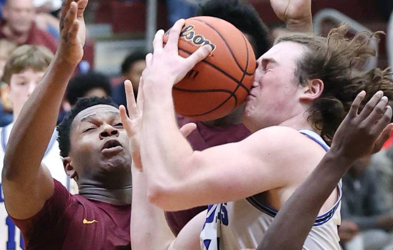 Hinckley-Big Rock's Martin Ledbetter takes a shot to the nose as he drives the lane against Chicago Marshall's Ricky Stanciel Wednesday, March 1, 2023, during their Class 1A sectional semifinal matchup at Elgin High School.