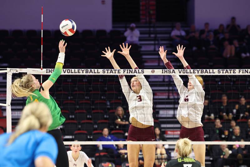 Prairie Ridge's Abigail Smith, center, and Sonora Bekere jump to block a hit during the Wolves' loss in two sets, 25-20, 25-18, in the IHSA Class 3A State semifinals on Friday, Nov. 14, 2025.