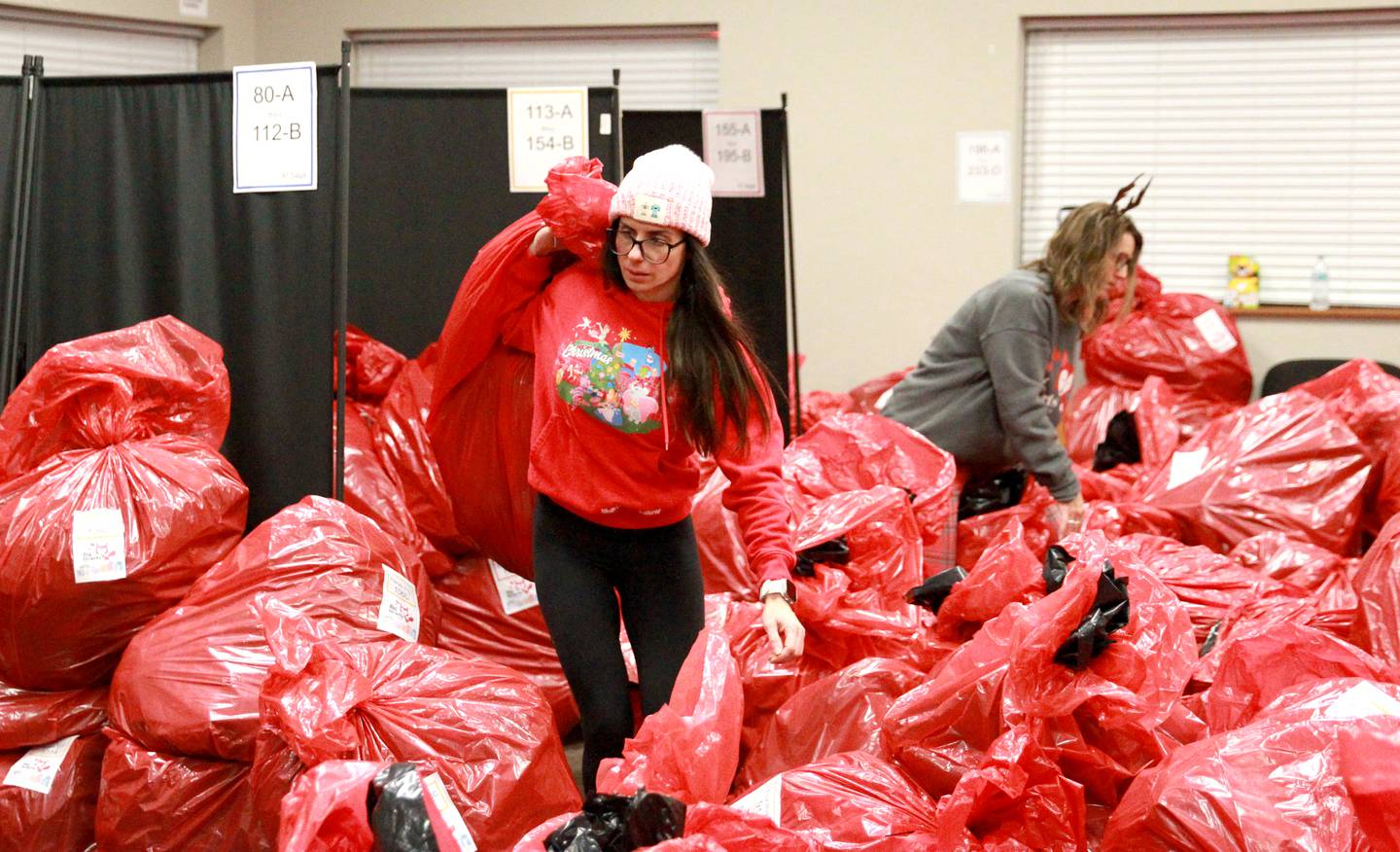 Daniela Saracco carries a bag full of gifts for one of 550 St. Charles School District 303 children on Tuesday, Dec. 3, 2024 for the annual Big Hearts of Fox Valley Christmas Gift Sponsorship Program.
