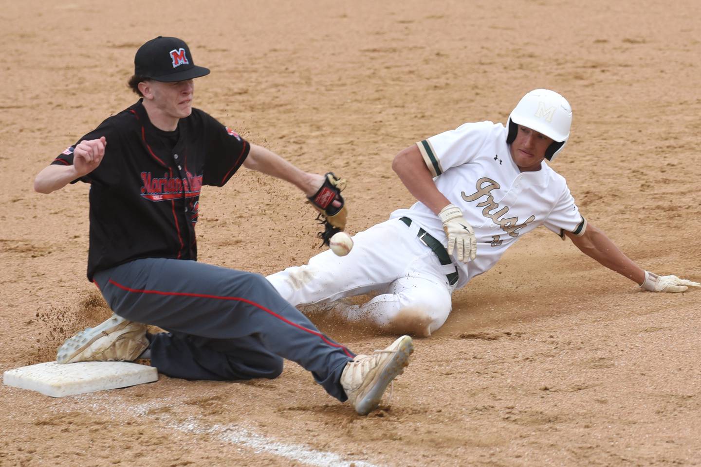 Bishop McNamara's Coen Demack, right, slides safely into third base as the ball gets past Marian Central's Blake Dominski during a game at Bishop McNamara Friday, April 17, 2026.