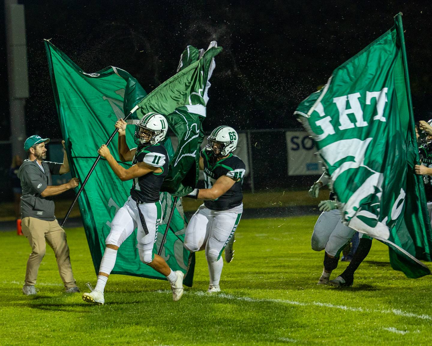 Joey Starks (11) of Dwight and teammate Jake Wilkey (65) lead team in pre-game run out on Friday, Sept. 19, 2025 at Dwight High School in Dwight.