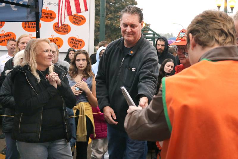 Pumpkin Parade Grand Marshall and former Sycamore High School Principal Tim Carlson (middle) is recognized with a plaque before the cake cutting Wednesday, Oct. 25, 2023, on North Maple Street adjacent to the DeKalb County Courthouse during the Sycamore Pumpkin Festival.