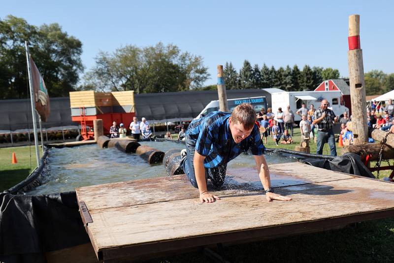 Lumberjack Tim Knutson crawls out of the tank after falling off a log during the boom run Saturday, October 5, 2024, at the Lumberjack Show in Rock Falls.
