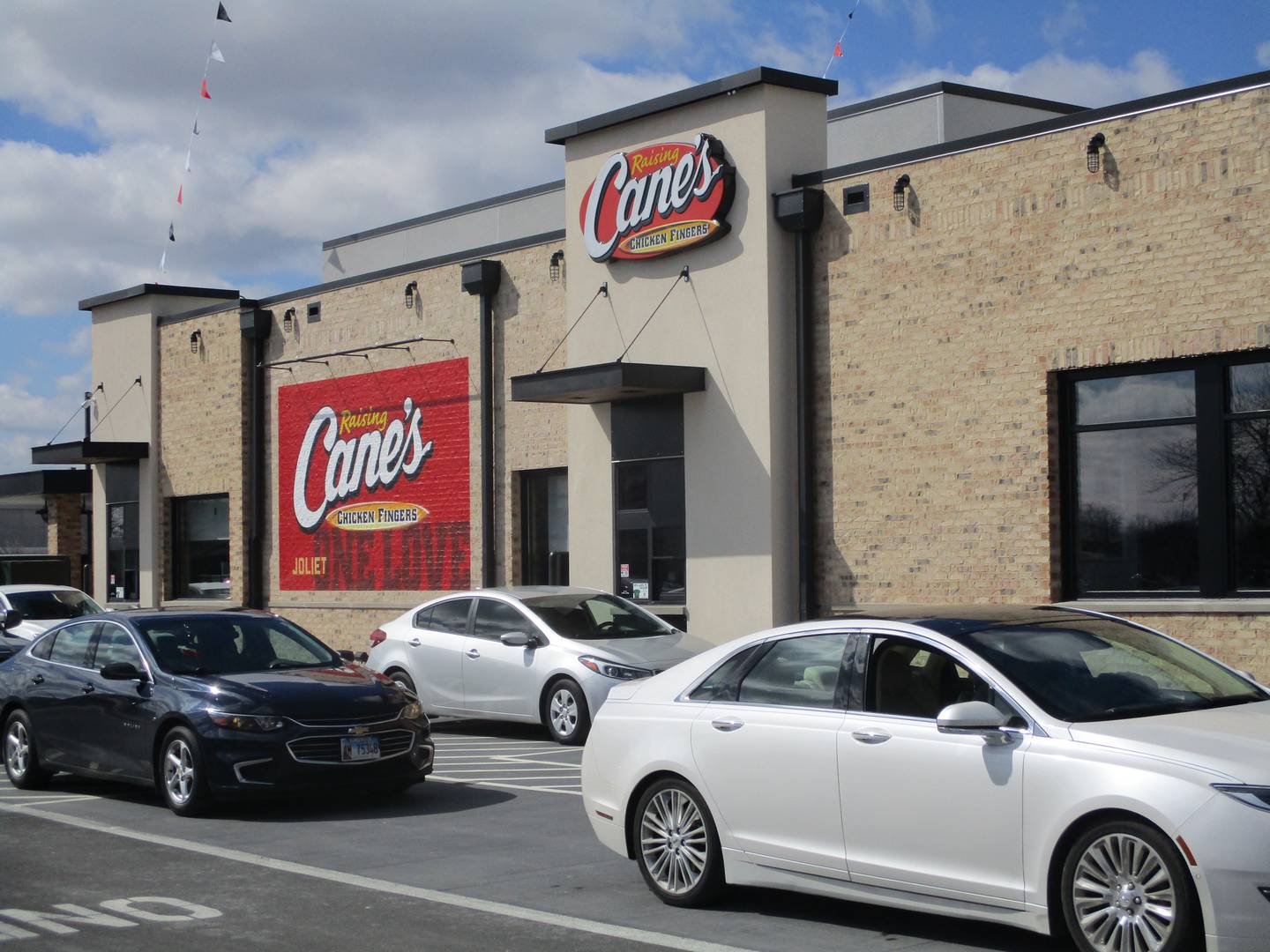 Cars are lined up outside the drive-thru window at Raising Cane's Chicken Fingers on Tuesday, March 8, 2022 at 3000 Plainfield Road in Joliet.