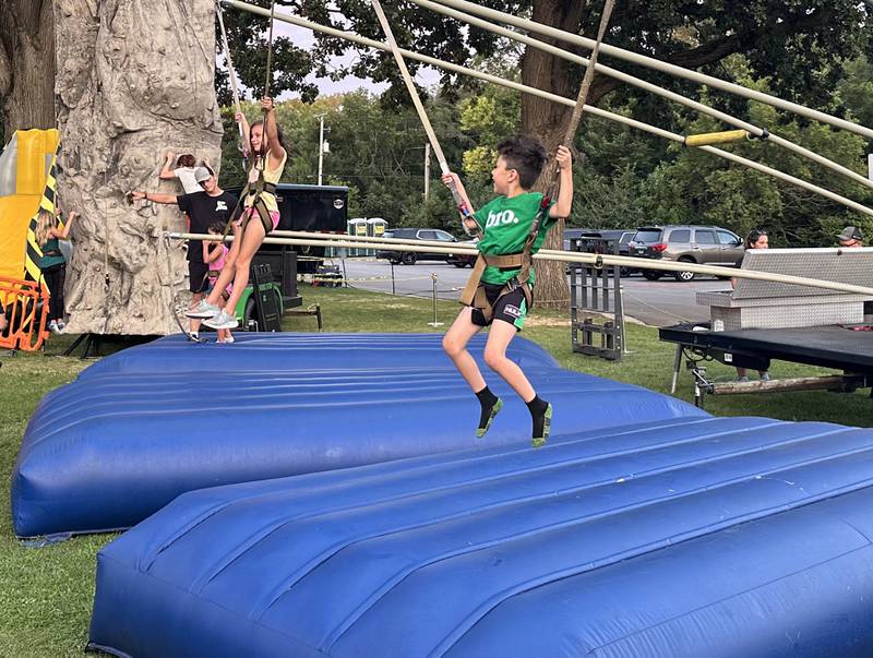 Kids bounce on trampolines during the Taste of the Illinois Valley festival on Saturday, Aug. 3, 2024 at Centennial Park in Peru.