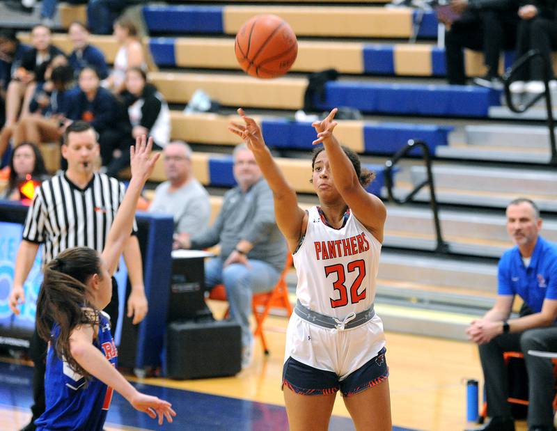 Oswego's Ahilivia East (32) shot and makes a three-point shot over a Glenbard South defender during a girls varsity basketball game at Oswego High School on Wednesday, Nov. 16, 2022.