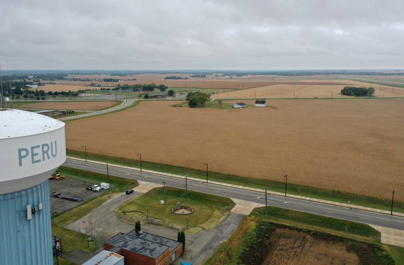An aerial view looking west of the Peru water tower of a farm field near the intersection of Midtown Road and Peoria Street on Tuesday, Sept. 24, 2024 in Peru. The City of Peru released a drawing at the past city council meeting to give residents an idea of how a multi-faceted sports complex and city center may be laid out in Peru.