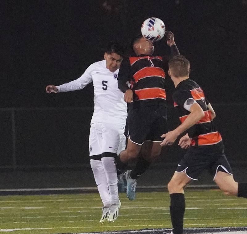 St. Charles East's Omar Lucio Ontiveros (11) goes up for a header against West Chicago's Gustavo Ramirez (5) during a class 3A sectional semifinal soccer match at West Chicago High School on Wednesday, Oct. 25, 2023.