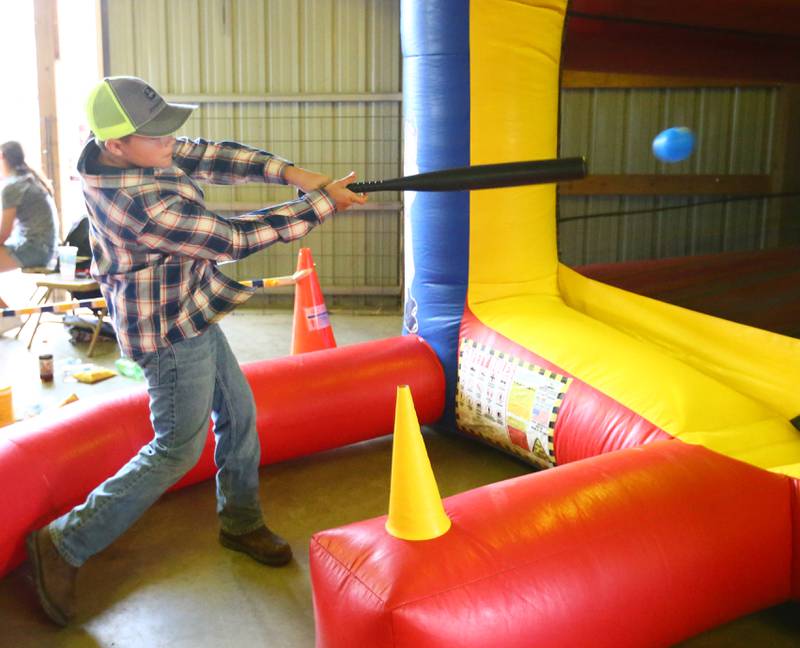 Parker Smith, 9, of Sparling, smacks a baseball at a inflatable baseball attraction during Family Night at the 100th annual Marshall-Putnam Fair in Henry on Thursday July 15, 2021.