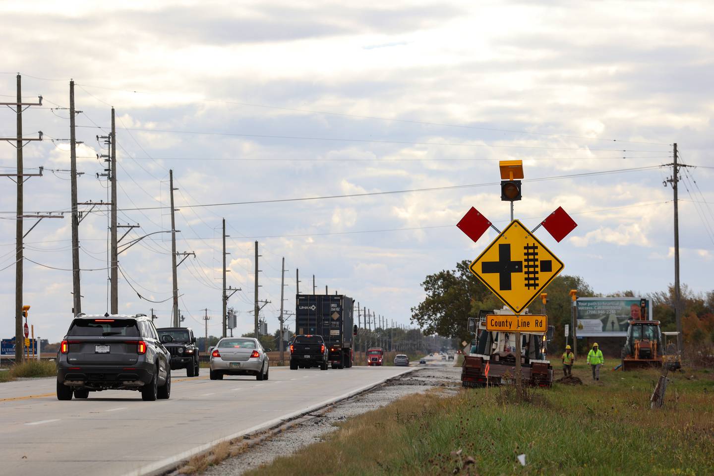 Drivers brake near County Line Road as they travel south on IL Route 50 on Tuesday, Oct. 21, 2025, as crews were at work preparing for a traffic pattern change, creating a four-way stop, at the accident-prone intersection where 18 accidents and four fatalities have occurred this year.