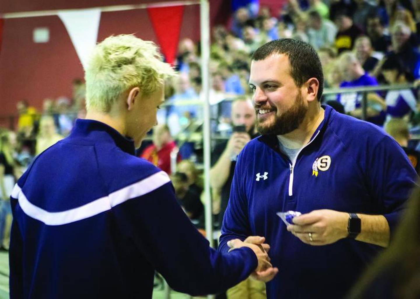Sterling coach Kyle Ruiz (right) hands Jack Wike his first-place medal after he won the 500 freestyle at the Rockford Jefferson Sectional in 2018.