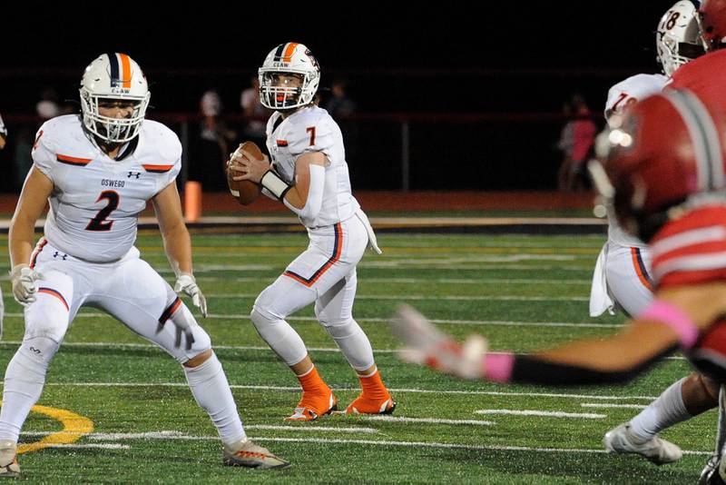 Oswego quarterback Brett Connolly (7) looks for a receiver against the Yorkville defense on Friday, Oct. 11, 2024, at Yorkville High School.