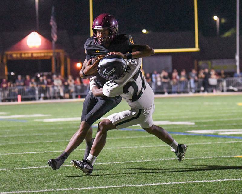 Montini Catholic's Israel Abrams (7) runs the ball and got brought down by Fenwick's Caleb Reed-Jennings (27) during the game on Friday Sept. 19, 2025, held at Montini Catholic High School.