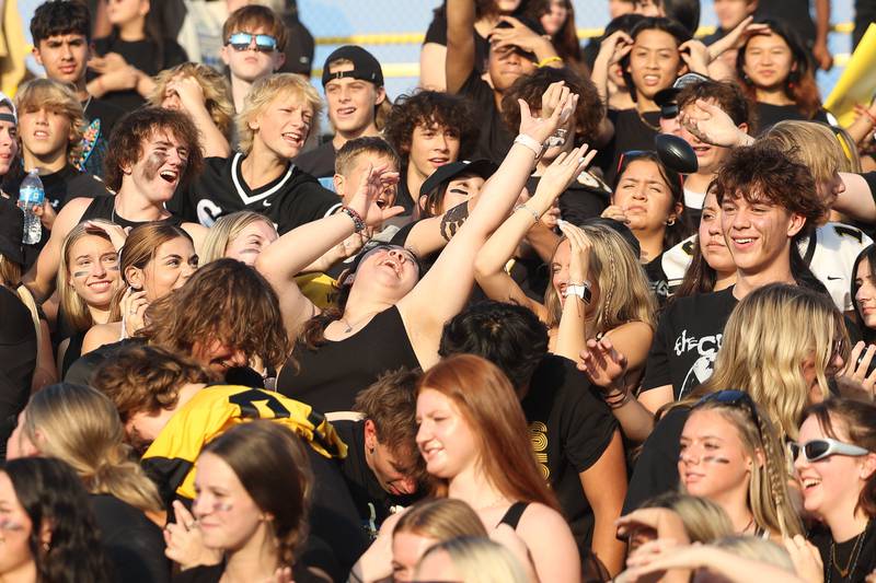 Joliet West students lunge for football thrown in the stands before the game against Shepard on Friday, Aug. 25, 2023 in Joliet.