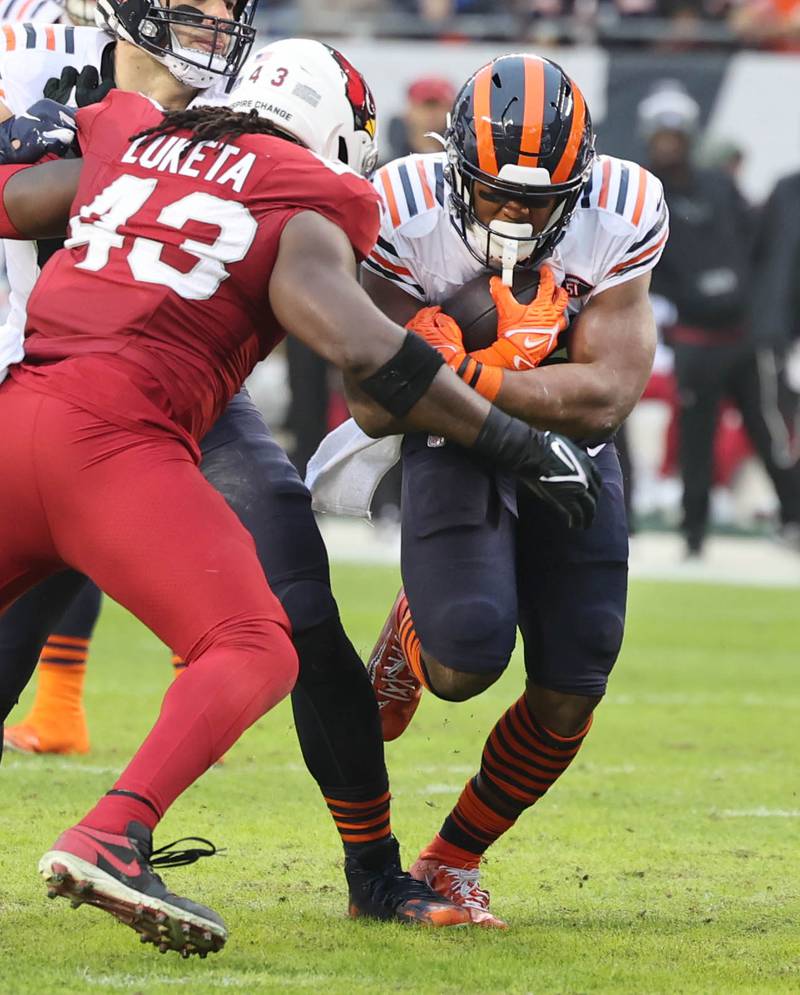 Chicago Bears running back Khalil Herbert tries to run through Arizona Cardinals linebacker Jesse Luketa during their game Sunday, Dec. 24, 2023, at Soldier Field in Chicago.