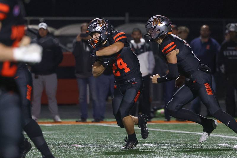 Minooka’s Hayden Bowman takes the hand off against Lincoln-Way East on Friday, Nov. 8, 2024 in Minooka.