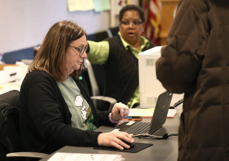 Election judges Terrilynn Morris (left) and Cindy Henderson check in voters for the primary election Tuesday, March 17, 2026, at the DeKalb County Administration Building in Sycamore.