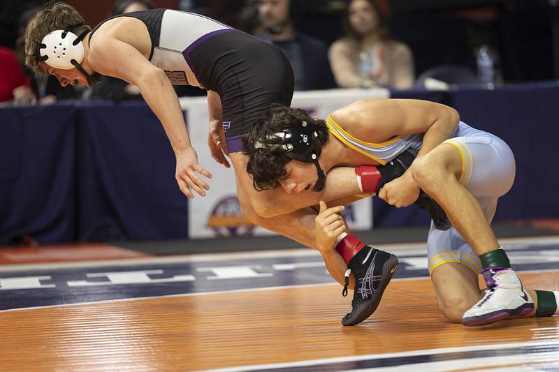Marquette’s Wesley Janick works the leg of Oakwood’s Weston Frazier Saturday, Feb. 21, 2026, at the IHSA wrestling finals in Champaign.
