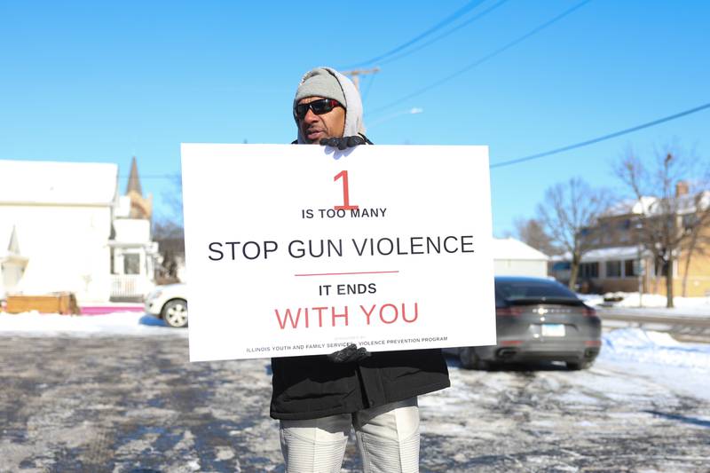 Tony Jones-Bey holds a sign along Richards Street for an Illinois Youth & Family Services anti violence rally on Monday, Jan. 26, 2026 in Joliet.