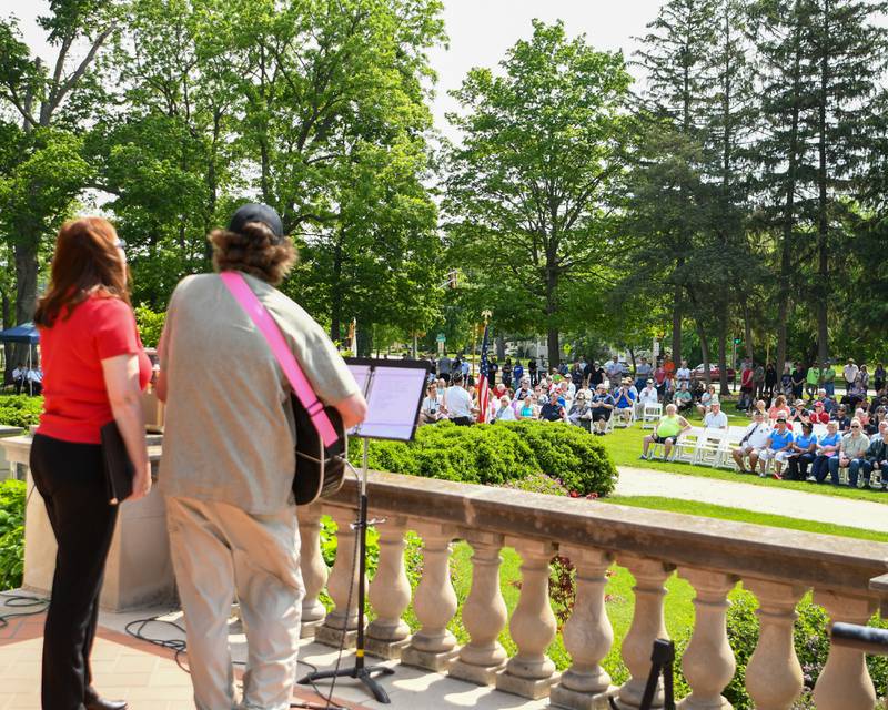 Terri Crain Goodman along with Ron Lofton sing and play the guitar as spectators listen during the Memorial Day ceremony held on the Ellwood house lawn in DeKalb on Monday May 30th.