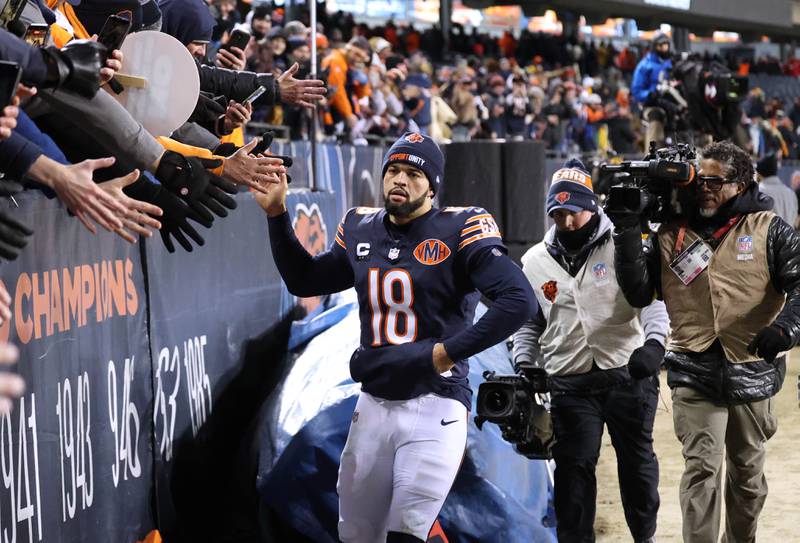 Chicago Bears quarterback Caleb Williams makes a loop around the stadium slapping hands with fans to celebrate after their 22-16 overtime win over the Green Bay Packers Saturday, December 20, 2025, at Soldier Field in Chicago.
