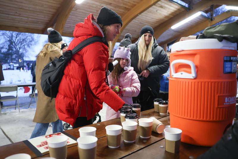 Alison Hunt and her daughter Ginny get their free cup of hot chocolate at Plainfield’s holiday kickoff Grinchmas on the Green on Saturday, Dec. 5, 2025 in Plainfield.