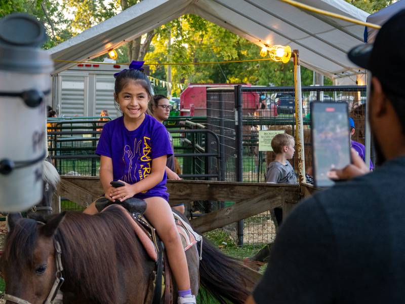 Child rides horse whilst being videotaped by father on Saturday, August 31, 2024 at the Tri County Fair in Mendota.