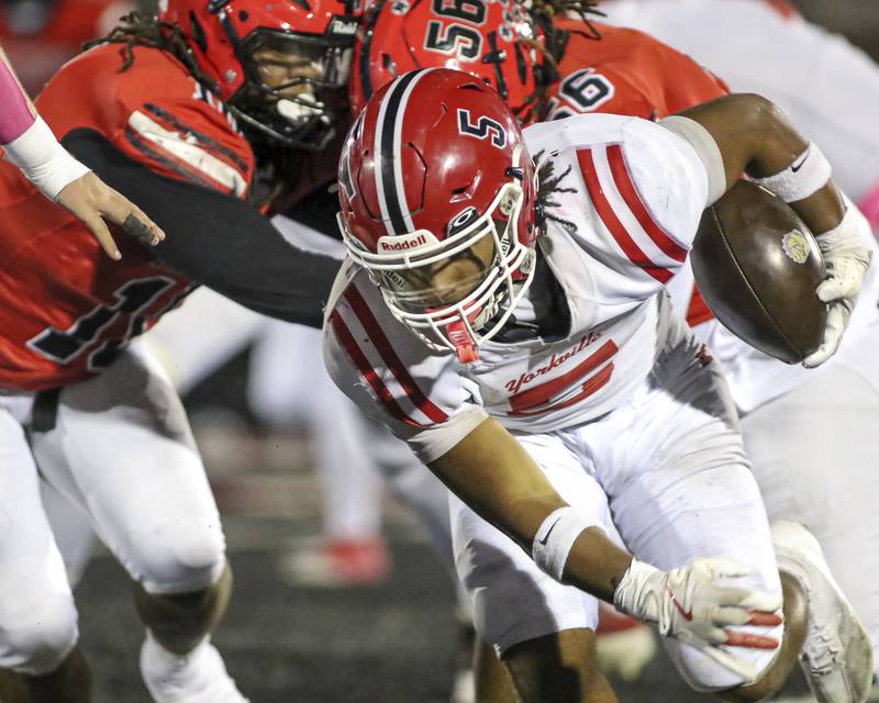 Yorkville's T.J. Harland (5) avoids the defense during football game between Yorkville at Bolingbrook Friday, Oct 24, 2025 in Bolingbrook.