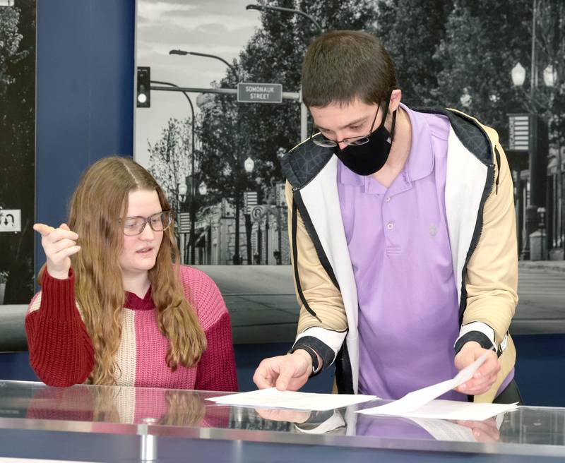 Educator Gregory D'Addario, who teaches TV production and english at Sycamore High School, goes through some notes with anchor Kennedy McCoy, a sophomore, before she goes on Wednesday, March 1, 2023, at the school.