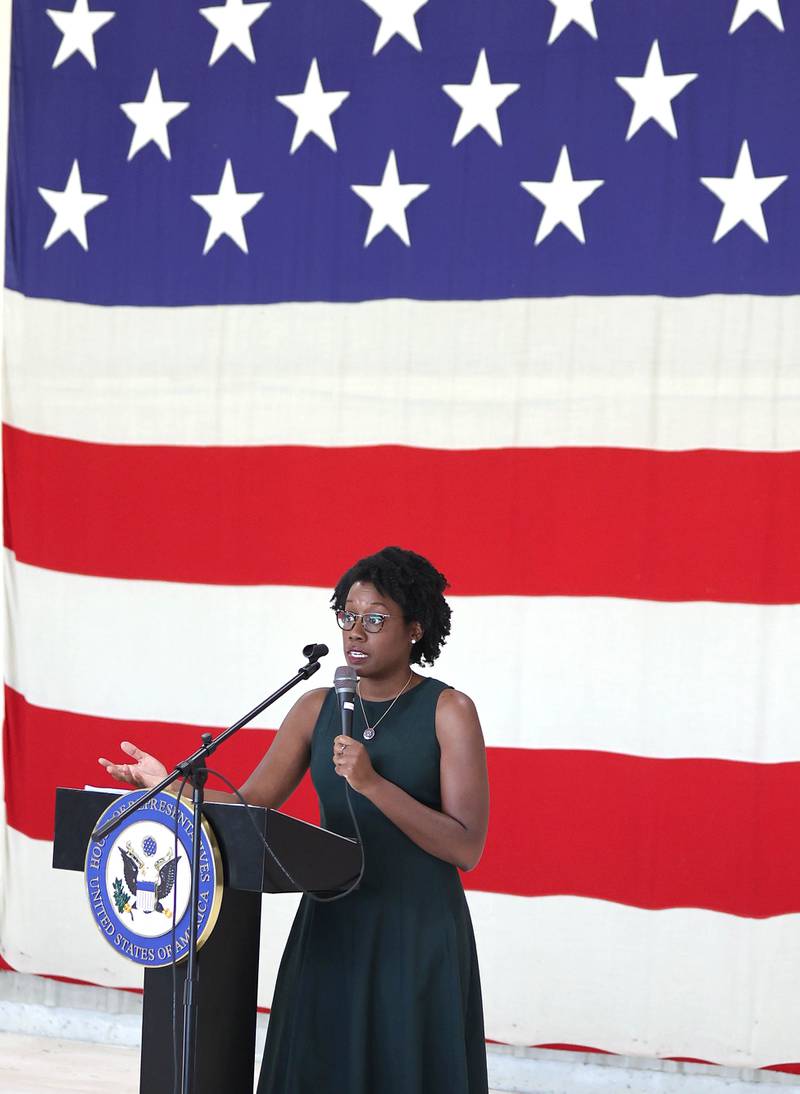 U.S. Rep. Lauren Underwood, D-Naperville, speaks in front of a large American Flag Tuesday, Aug. 23, 2022, during a town hall meeting in one of the hangers at the DeKalb Taylor Municipal Airport.