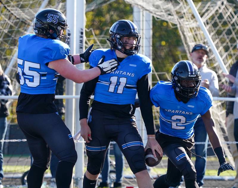 St. Francis' Alessio Milivojevic (11) is greeted in the end zone by fellow team mates after scoring a touchdown on a keeper against Morgan Park during a class 5A state quarterfinal football game at St. Francis High School in Wheaton on Saturday, Nov 11, 2023.