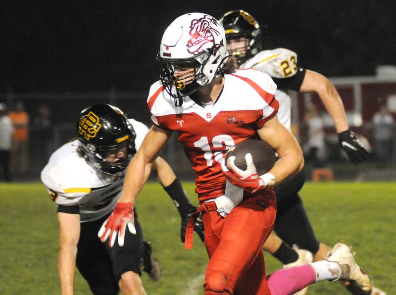 Streator's Cade Stevens (13) runs the ball past the Reed-Custer defense of Vander Dransfeldt (3) and Jace Christian at SHS Athletic Fields on Friday, October 8, 2021.